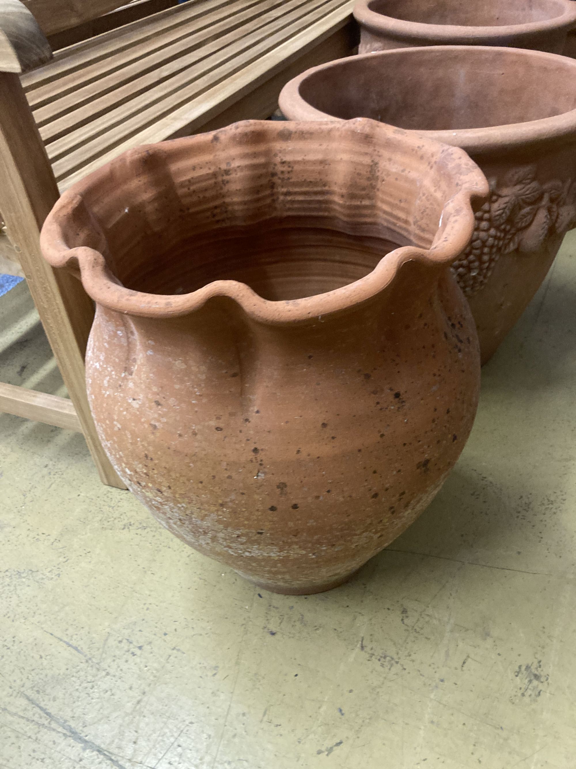 Four circular terracotta garden urns, largest 50cm diameter, 46cm high